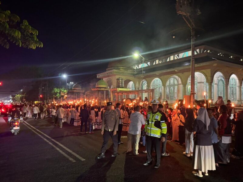 Petugas kepolisian dari Polres Kotamobagu saat bersiaga menjaga ketertiban arus lalu lintas dan mengawal jalannya Pawai Obor Gema Gemilang Muharram NU 2026 di Kotamobagu. Sumber: Humas Polres Kotamobagu